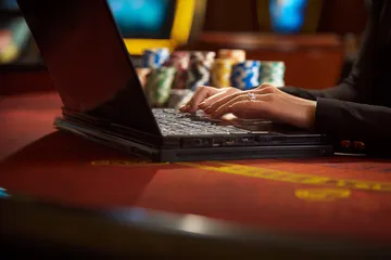 A glowing roulette wheel with cascading chips, symbolizing the engaging live and instant-win games available on TK99.