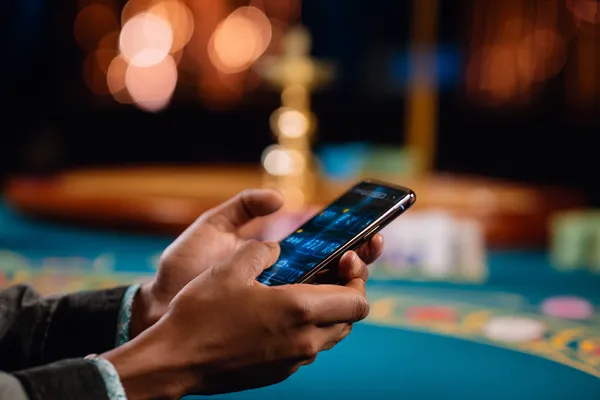 A player using their smartphone during a festive local event, representing TK99’s fully mobile-friendly casino.